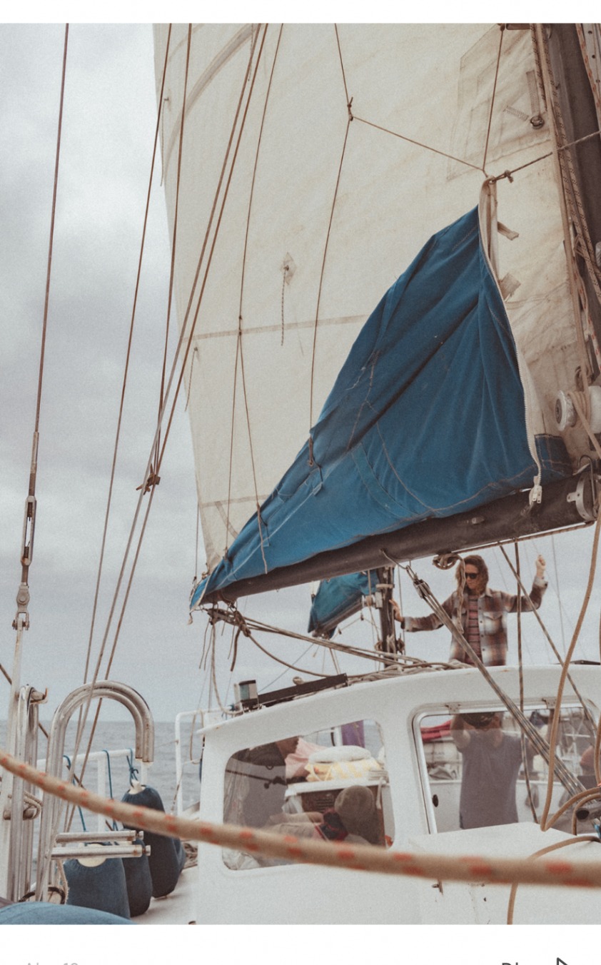 Guests moving around the yacht beneath raised sails