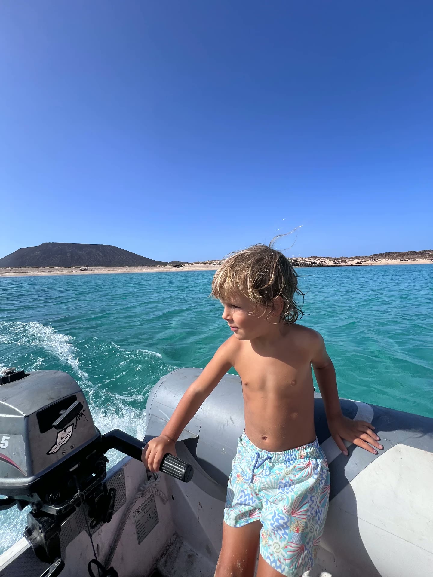 Young guest steering the dinghy towards Lobos island