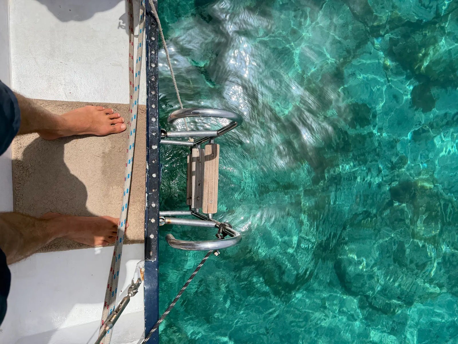 Swim ladder over turquoise water at an anchorage