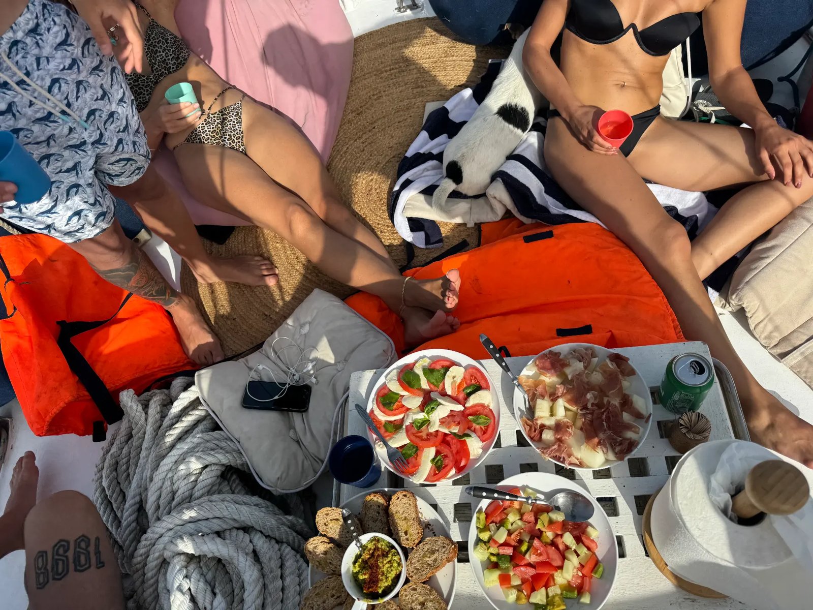 Deck picnic with tomato salad, ham, melon and bread