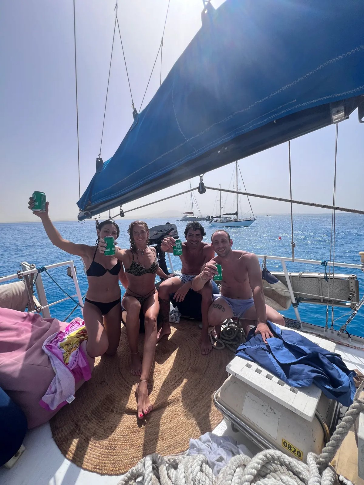 Four friends toasting with cold drinks on the deck